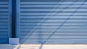 Garage door with horizontal slats and shadows, representing modern design and functionality for Katy, TX homeowners considering upgrades.